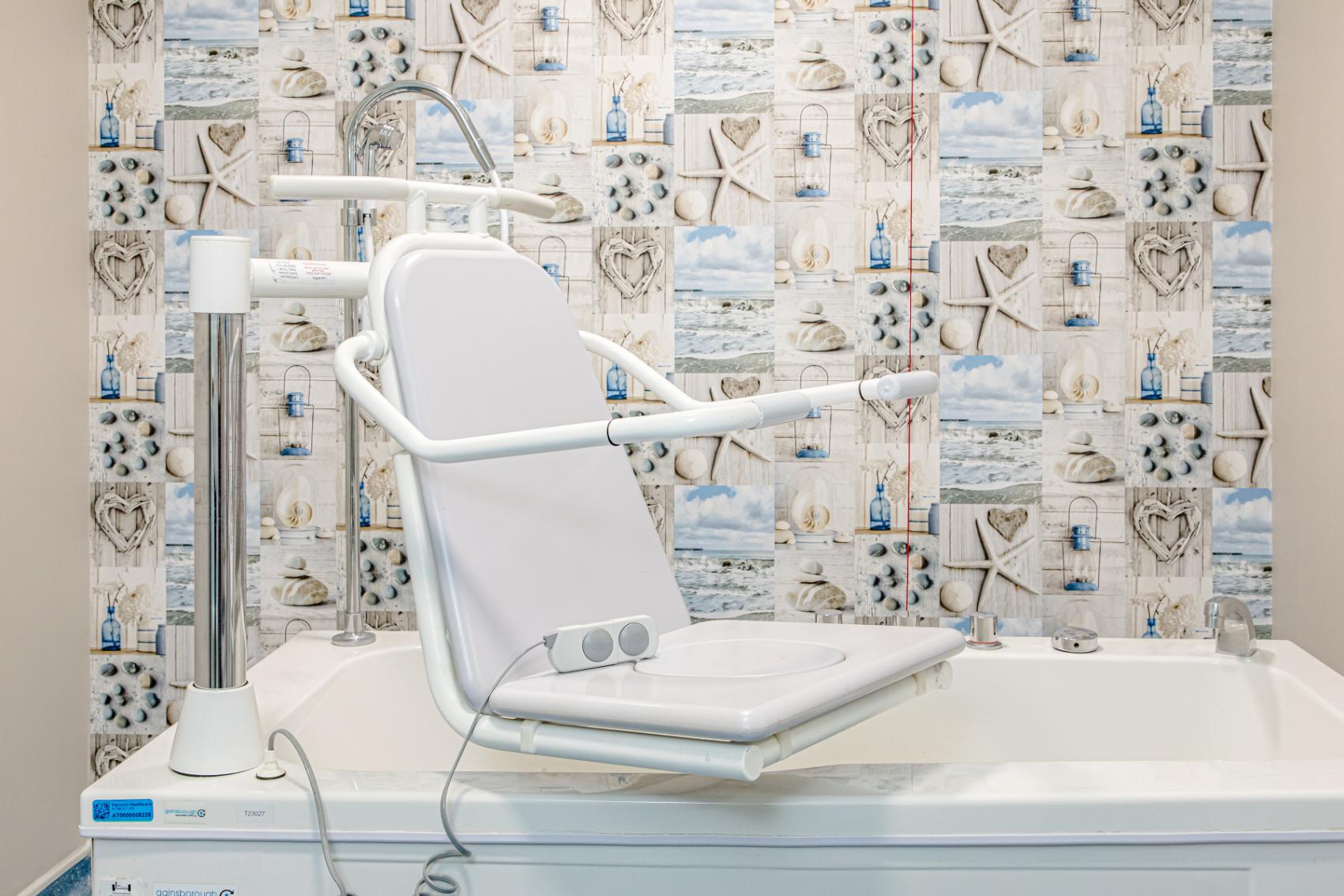 accessible bath with with a remote and beach themed wallpaper